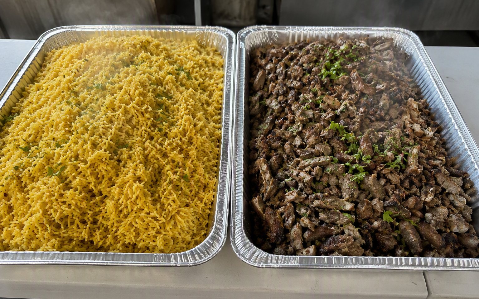 Full catering pans of seasoned rice and lamb