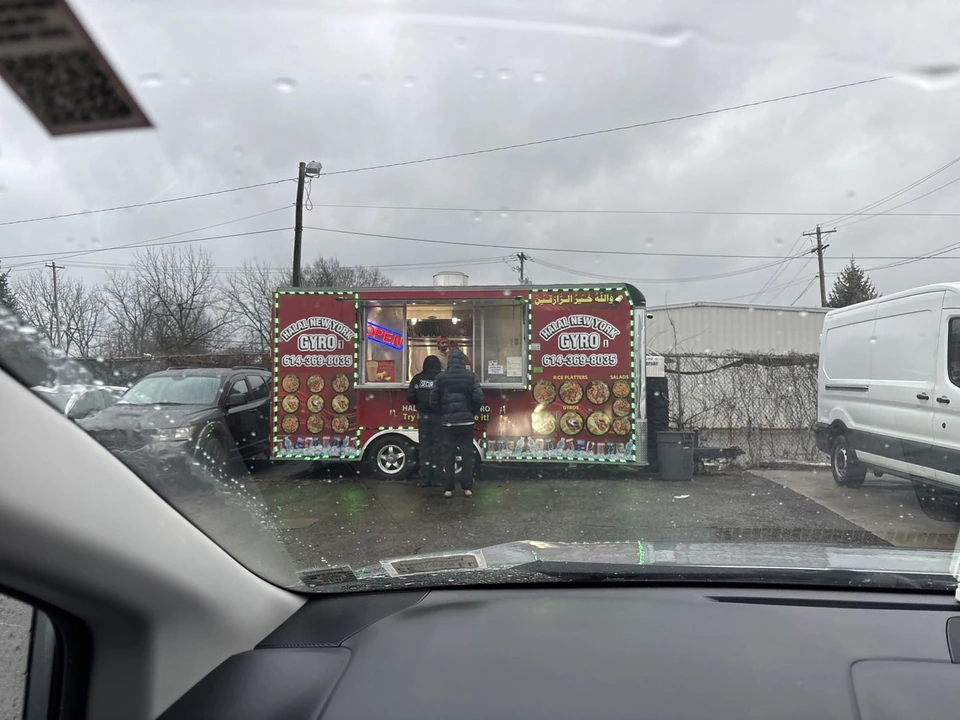 Two customers ordering at the trailer window in sleet